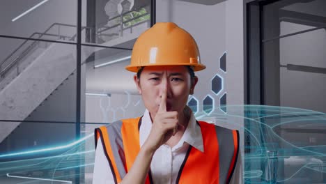 primer plano de una ingeniera asiática con casco de seguridad haciendo un gesto de silencio mientras está de pie con el concepto de vehículo eléctrico