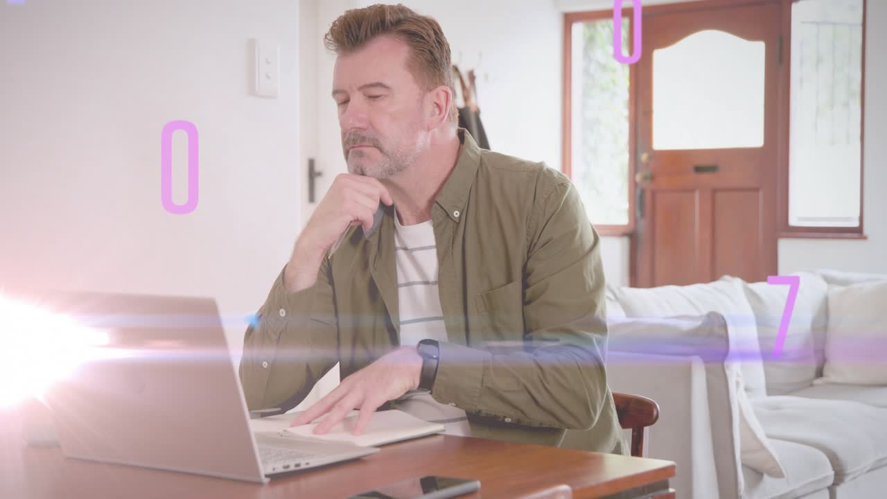 Hombre maduro escribiendo y haciendo pausas en una mesa, generando una superposición alfanumérica mientras analiza datos tecnológicos