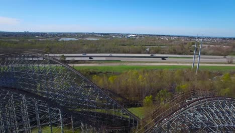 Aerial-shot-over-an-abandoned-and-decaying-theme-park-and-rollercoaster