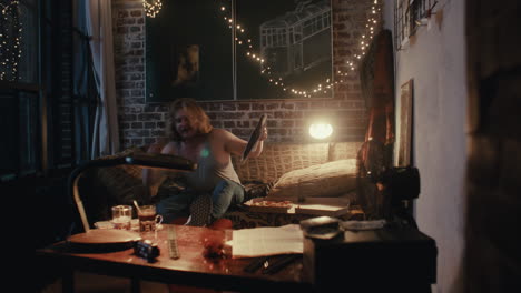 man relaxing at home with pizza and drinks