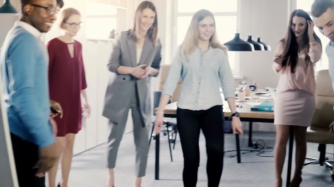 счастливые случайные работники играют в мяч в офисе. молодые многоэтнические сотрудники празднуют бизнес-успех с деятельностью 4k