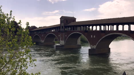 covered bridge or ponte coperto with chapel over ticino river in pavia, italy