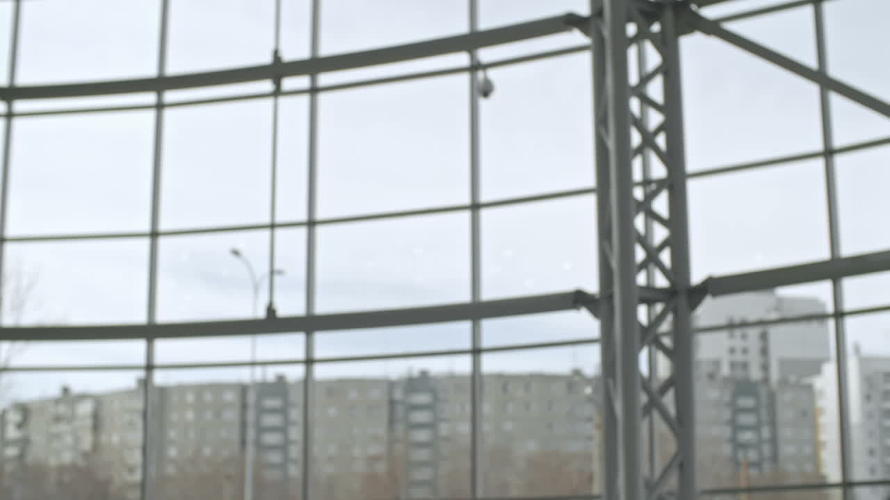 два улыбающихся молодых бизнесмена пожимают руки, чтобы поздороваться и разговаривают в холле современного бизнес-центра, замедленная съемка среднего плана