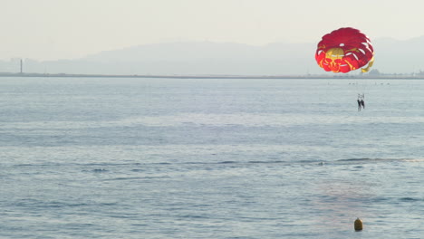 Gente-Haciendo-Parasailing-Detrás-De-Una-Lancha-Rápida-En-El-Mar