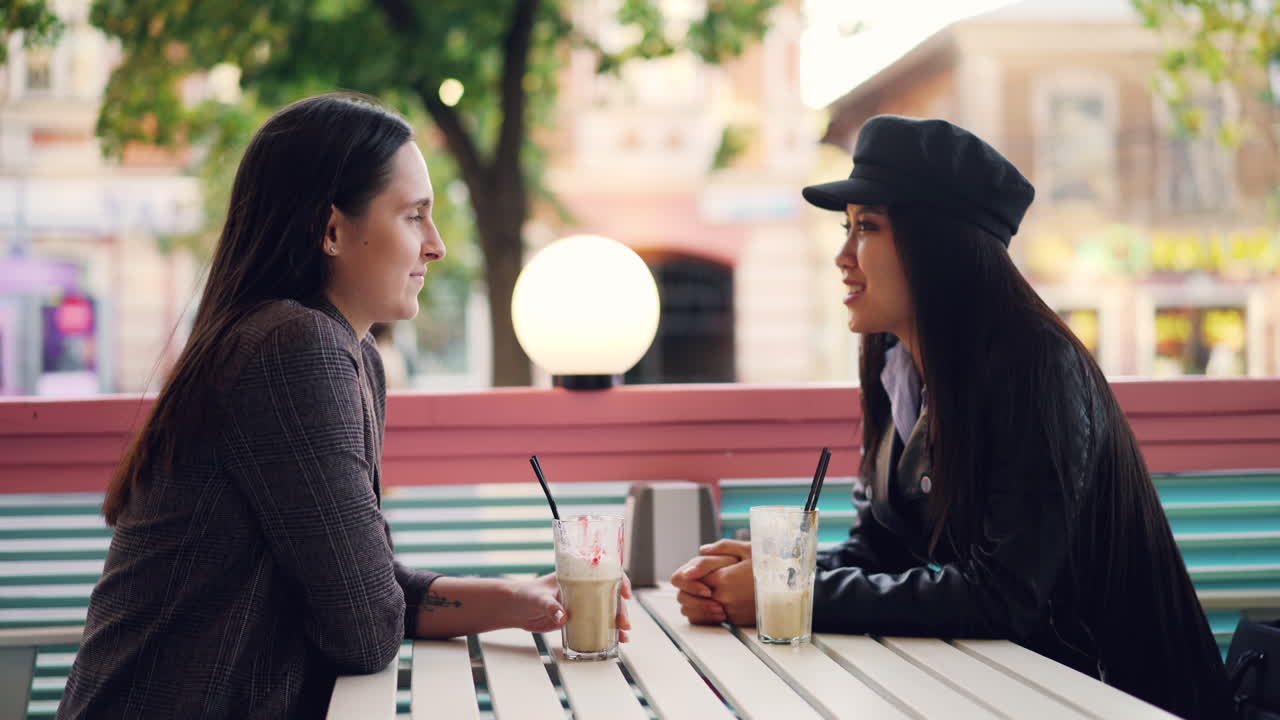 두 여인이 카페에서 대화하고 있다.