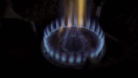 slow motion blue flames from kitchen gas stove, high heat cooking for enhanced flavor and aroma in culinary preparation.