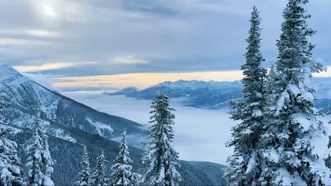 fast time lapse of mt cartier and the valley connected from the top of mt mackenize revelstoke british columbia at sunrise with a low beautiful cloud layer and feet of snow on the ground