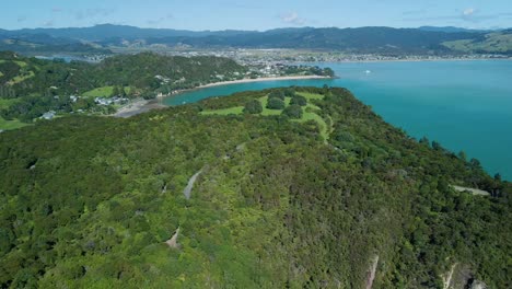 green new zealand mountains with hiking trails and ocean backdrop