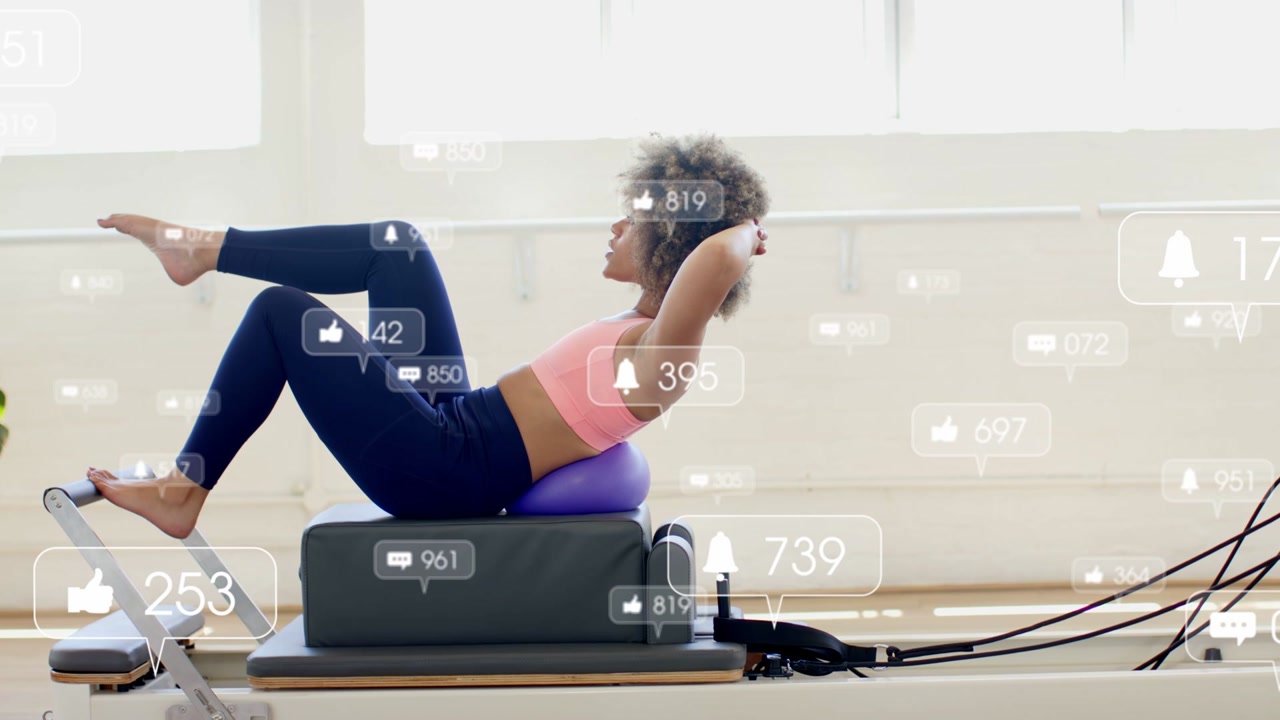 Vertical video: Woman doing reformer crunch in fitness studio each rep adding likes and toning core