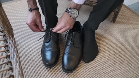 close up of man leg and hands tying shoe laces