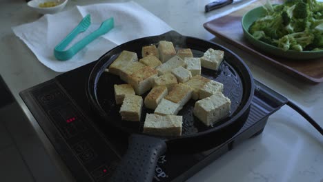 disparo aéreo de tofu en una sartén amplios ingredientes especiales para cocinar una comida dos latas de frijoles arroz plátano aguacate cebolla roja y cilantro