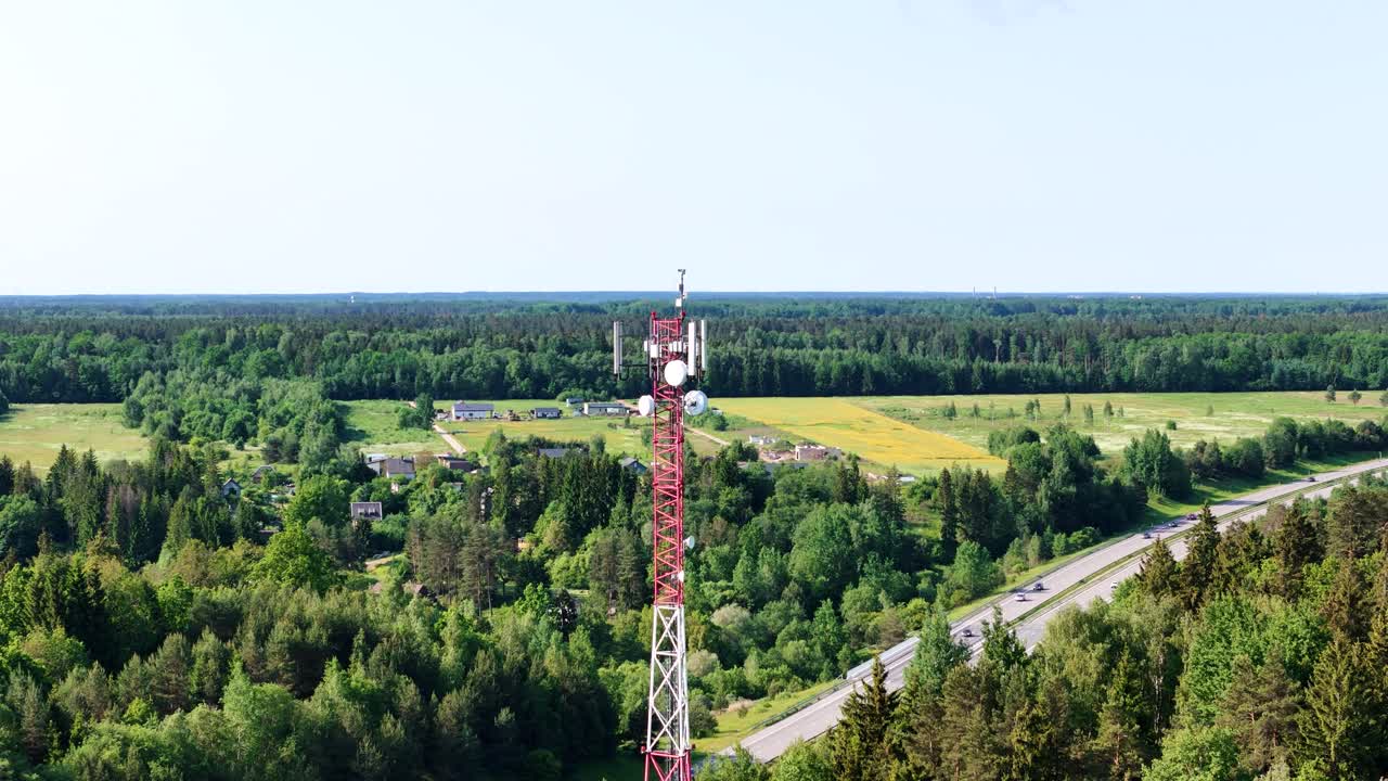 Green Lithuania landscape and cell tower, aerial orbit view