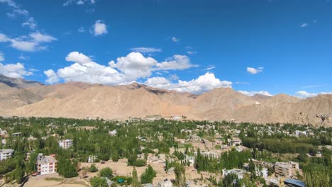 wide pan shot of upper himalayas landscape with clouds and leh city in ladakh india