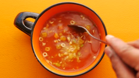 stirring a bowl of tomato soup