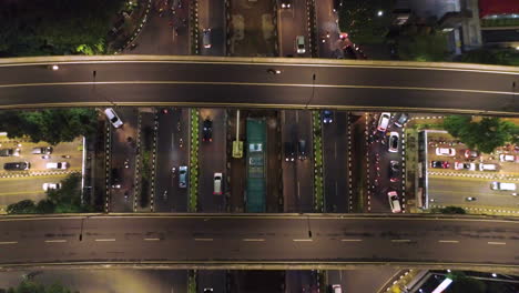 jakarta kuningan district , nite time flying, above and between building top shot of busy intersection in kuningan area, creates a urban felling with lots of traffic