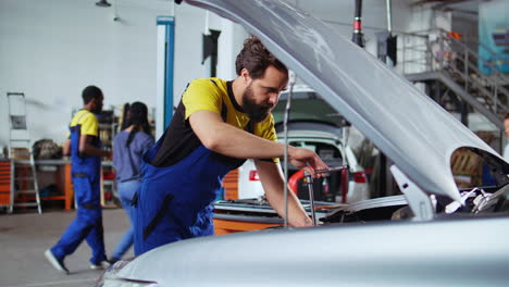 mechanic replaces car engine in garage