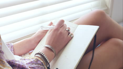 Una-Chica-Guapa-Planeando-Su-Viaje-Por-Carretera-En-Un-Cuaderno-En-Casa