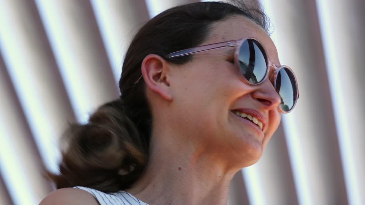 mujer feliz y sonriente con gafas de sol redondas risa sincera