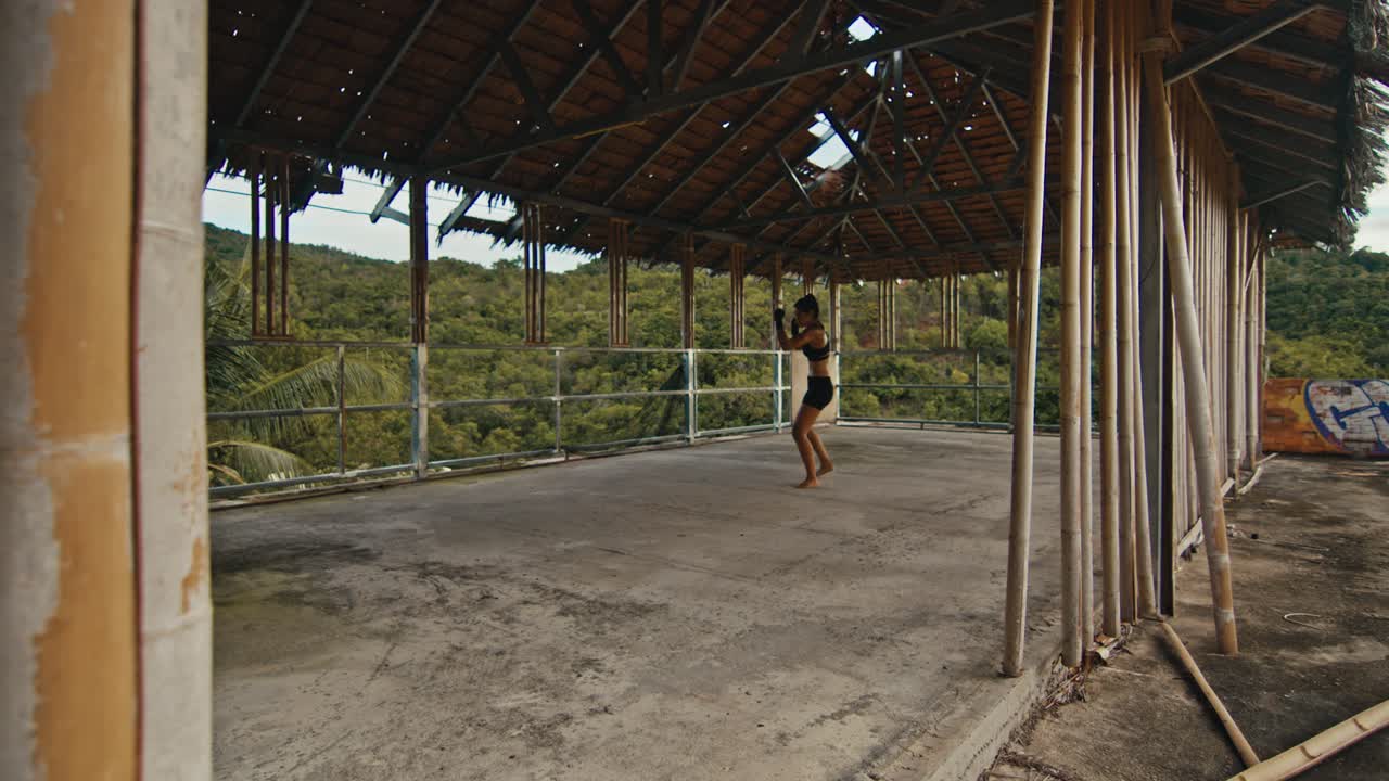 Tropikal bir yerde terk edilmiş çatıda dans eden kadın