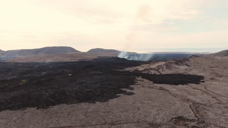 paisaje volcánico inhóspito con un volcán activo humeante, islandia
