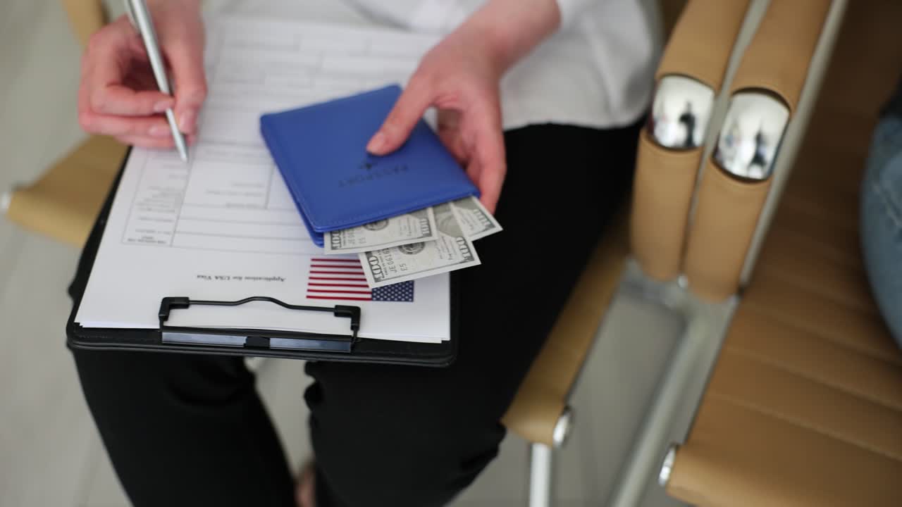 People filling out a US visa application form with money