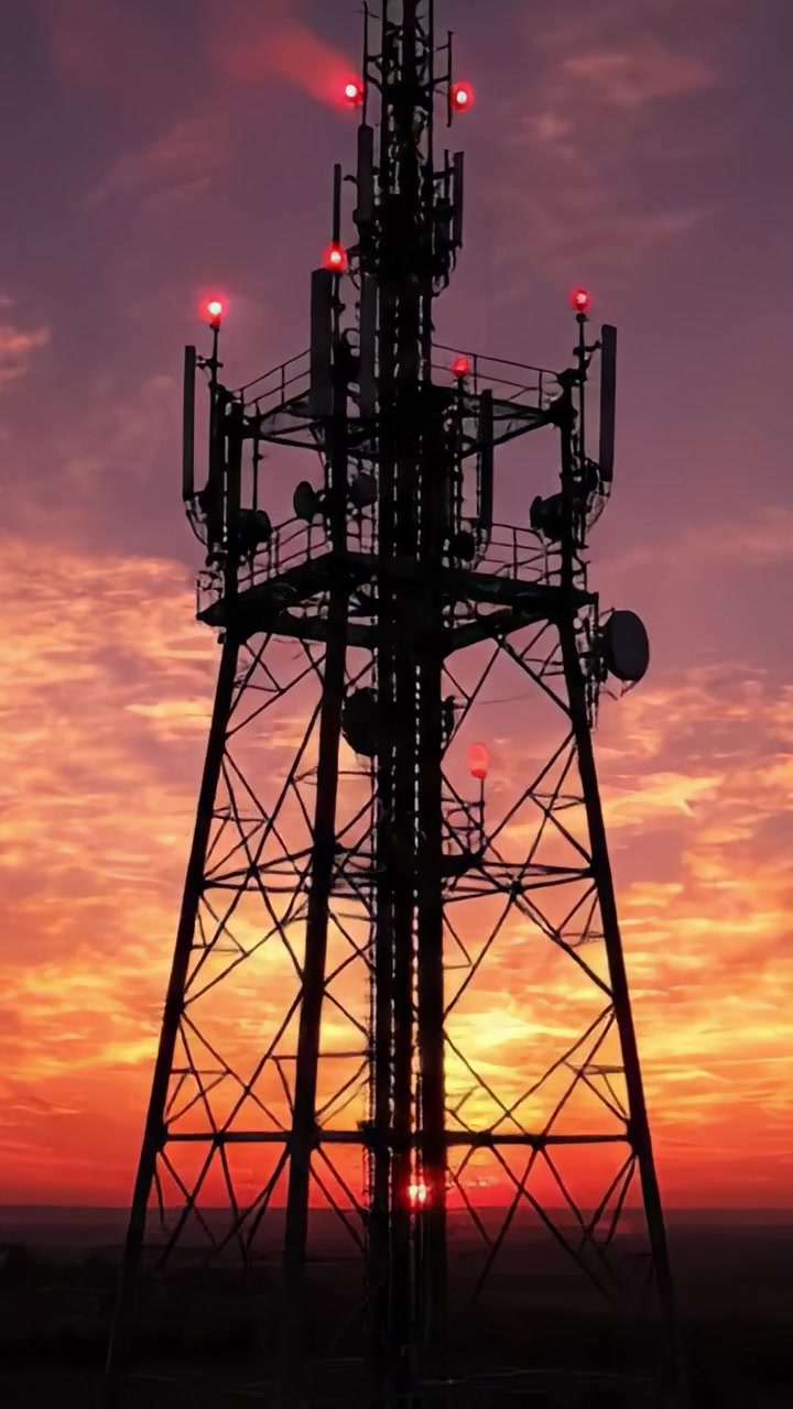 Maestose Torri di Comunicazione Sagomate Contro un Vibrante Cielo al Tramonto: Uno Straordinario Contrasto tra Tecnologia e Bellezza della Natura
