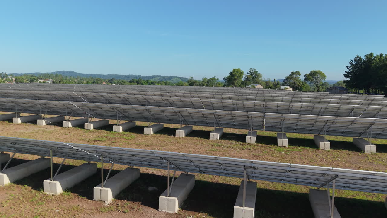 vuelo bajo de drones sobre paneles solares, mostrando sus bases montadas en tierra.