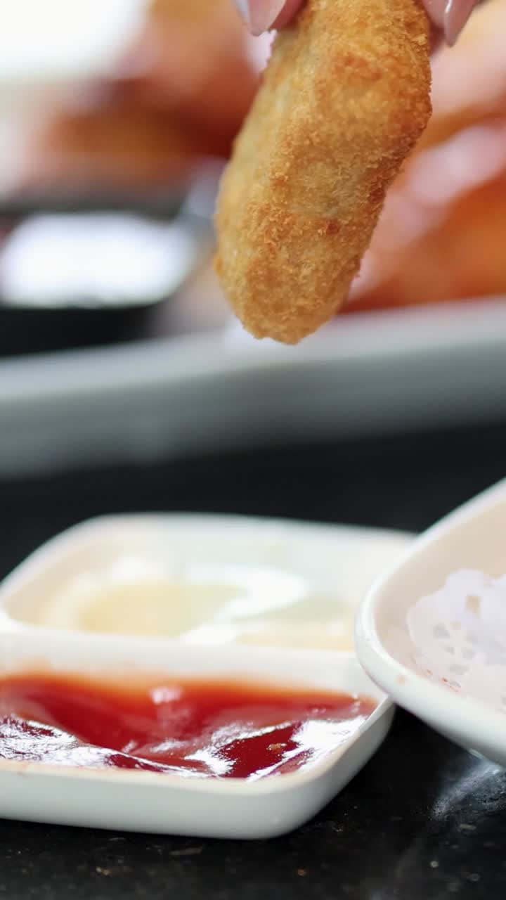 Nuggets being dipped in various sauces