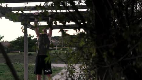 Sportsman-doing-push-ups-on-a-wooden-beam-in-a-park