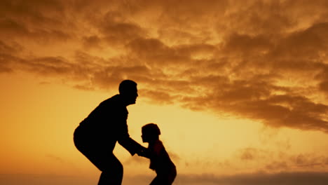 father and child silhouette at sunset