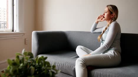 thoughtful woman sitting on sofa