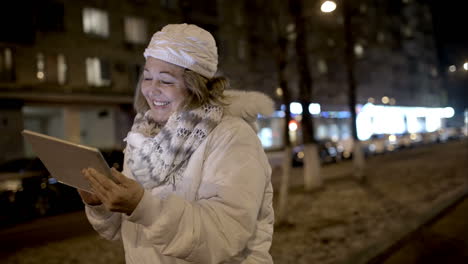 Happy-woman-watching-something-on-pad-during-evening-walk