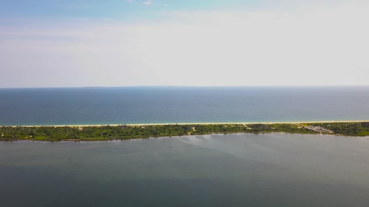 Aerial circling over isthmus between pond and sea, Burlingame Park. United States