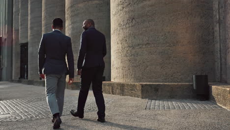 businessmen walking and talking outdoors