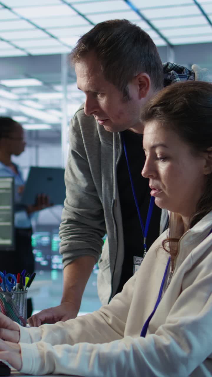 Vertical video IT team members programming scripts on computer, employing AI machine learning