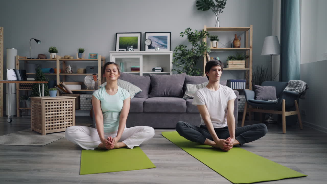 pareja practicando yoga en casa