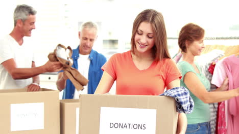 familia de voluntarios felices separando las donaciones