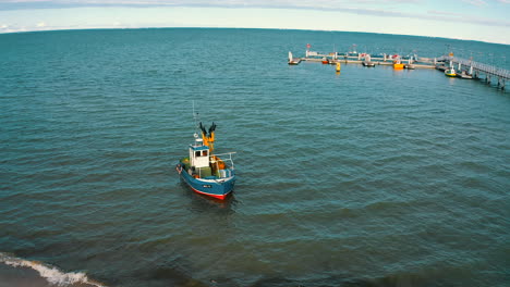 aerial view of fishing boat slowly going towards the sea