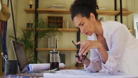 caucasian woman leaning on desk, working from home