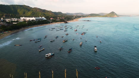 Boats-docked-in-the-ocean-next-to-the-coastline-of-Kuta-Mandalik