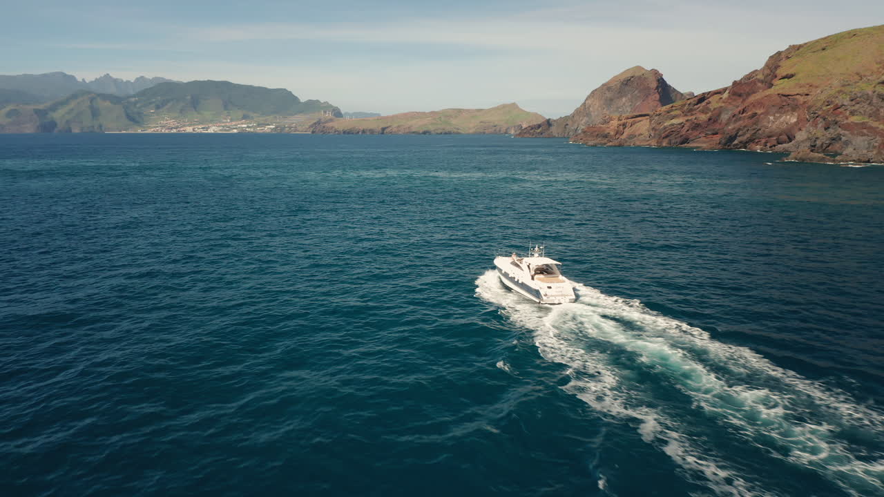 Veduta aerea di una barca che si muove lentamente nelle acque blu dell'oceano all'isola di Madeira