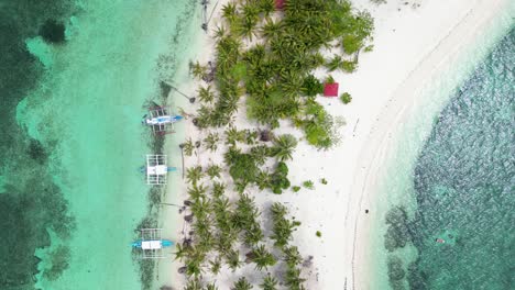 Bird's-eye-view-of-banca-boat-and-tropical-beach-luxury-bungalows-on-canimeran-island