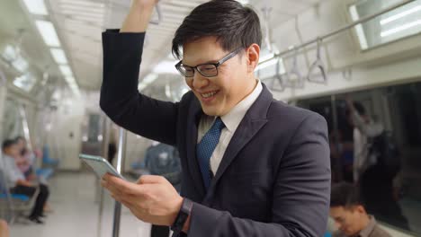 businessman using mobile phone on public train