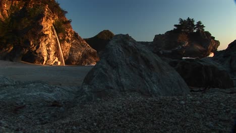 longshot of a waterfall crashing down in the julia pfeiffer state park along the rocky california coast