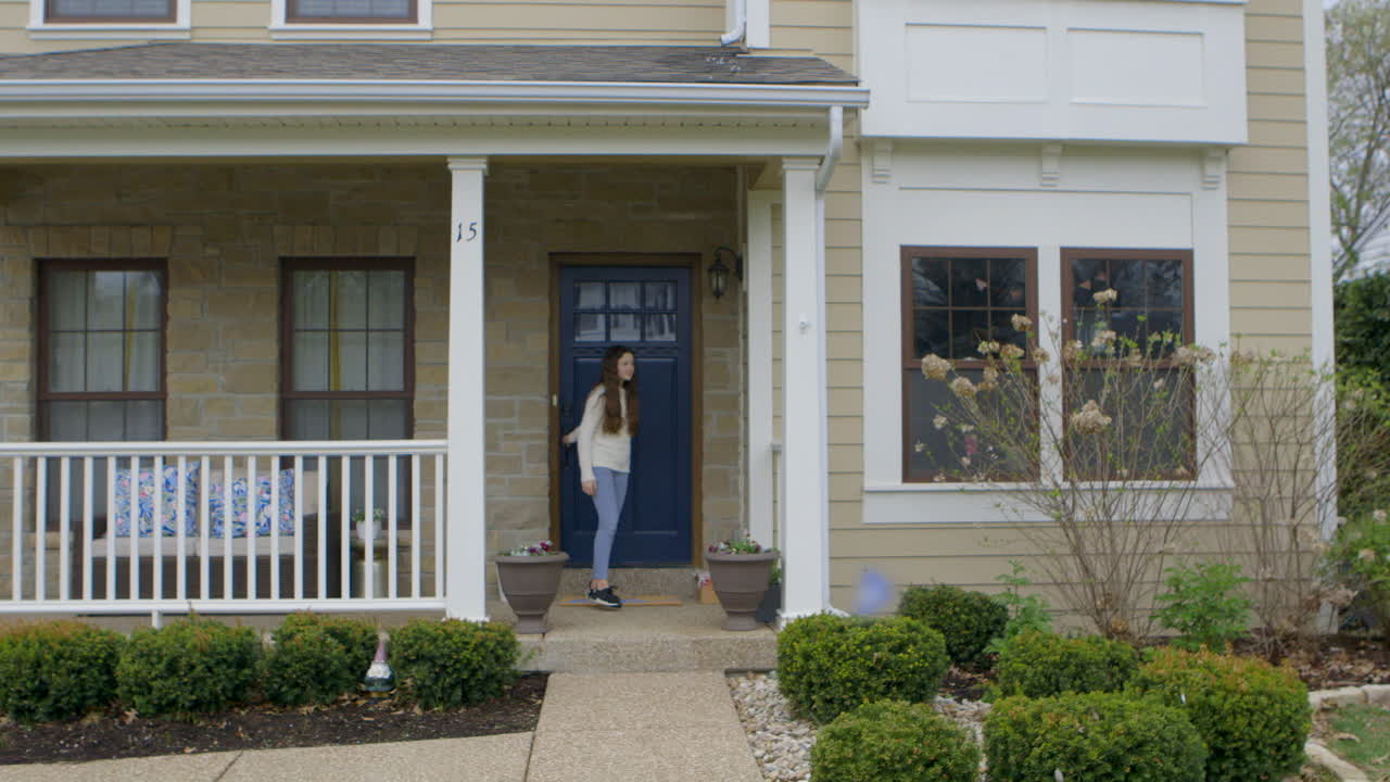 Girl alone at home walks out of house and looks up and down the street
