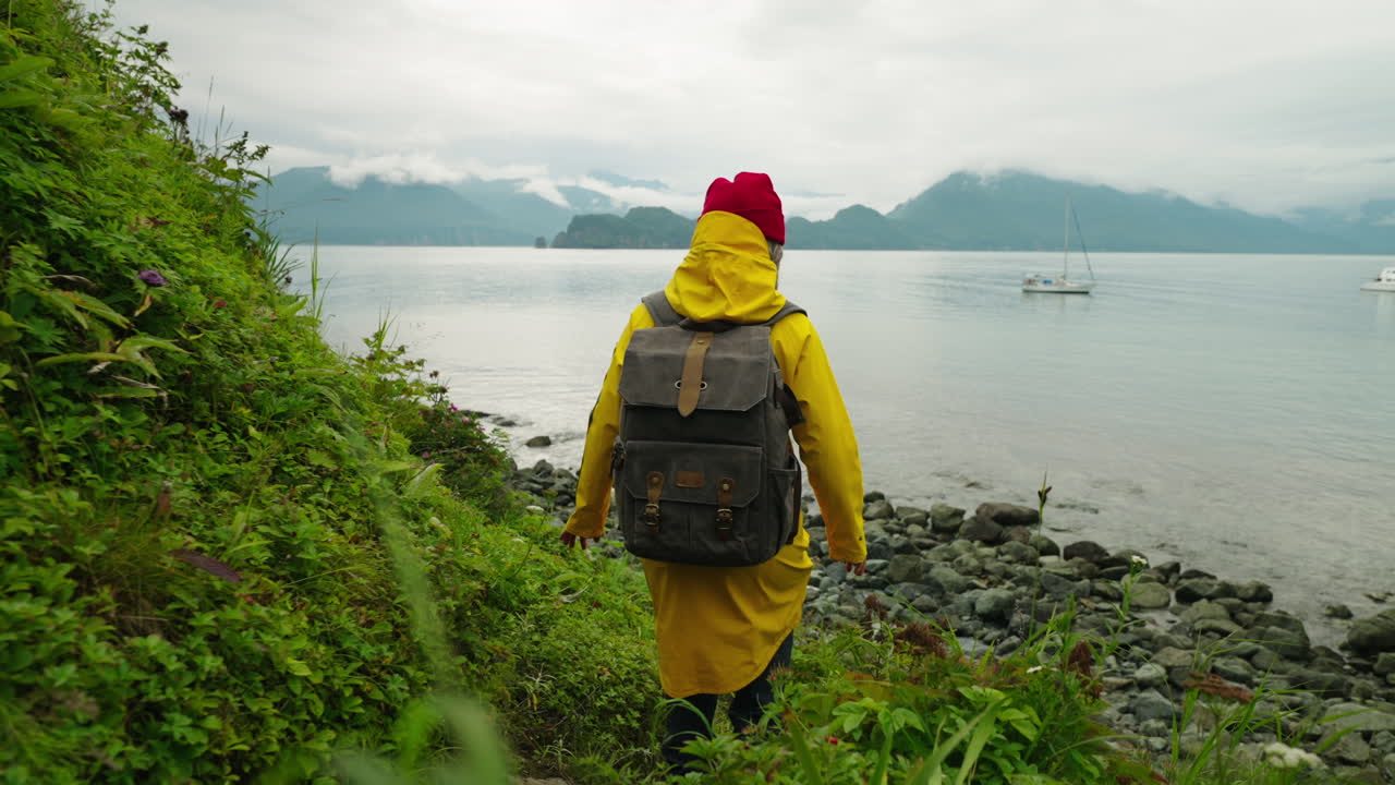 Woman Hiking Along the Coastline on a Cloudy Day
