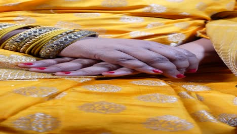 woman's hands with bangles and saree