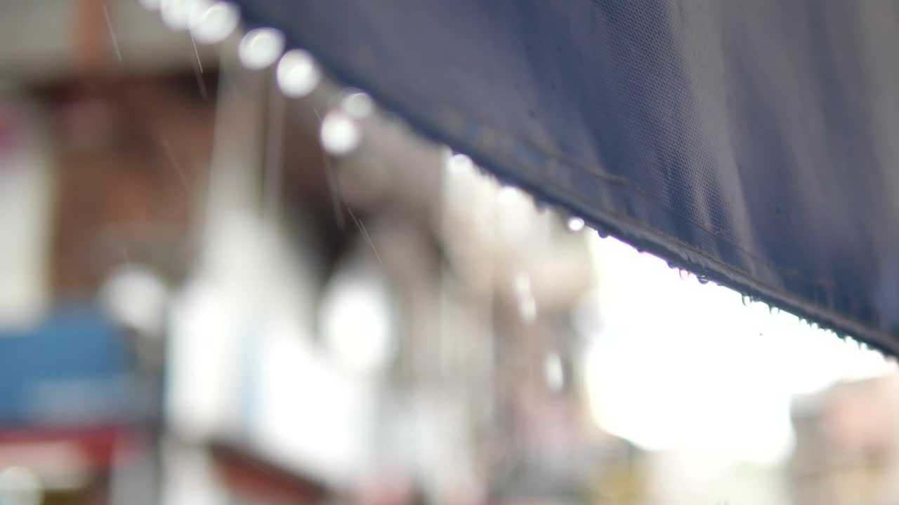Rainwater dripping from a blue awning