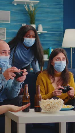 vertical video: concentrated multiracial friends playing video games with joystick