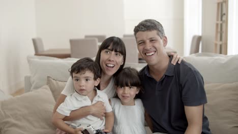 padres felices con dos hijos viendo su programa favorito